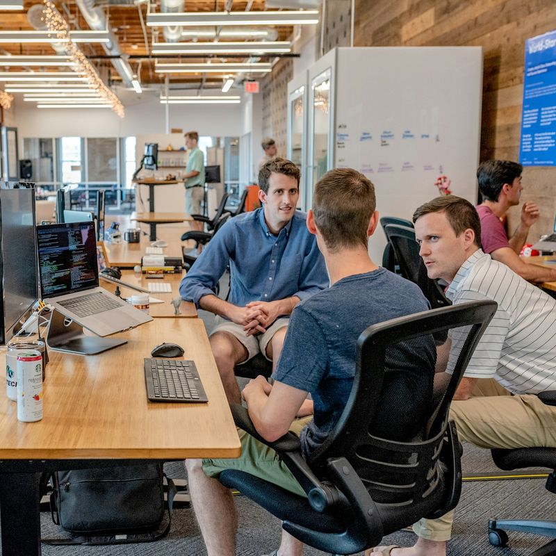 Team members collaborating at desks in a bright open office